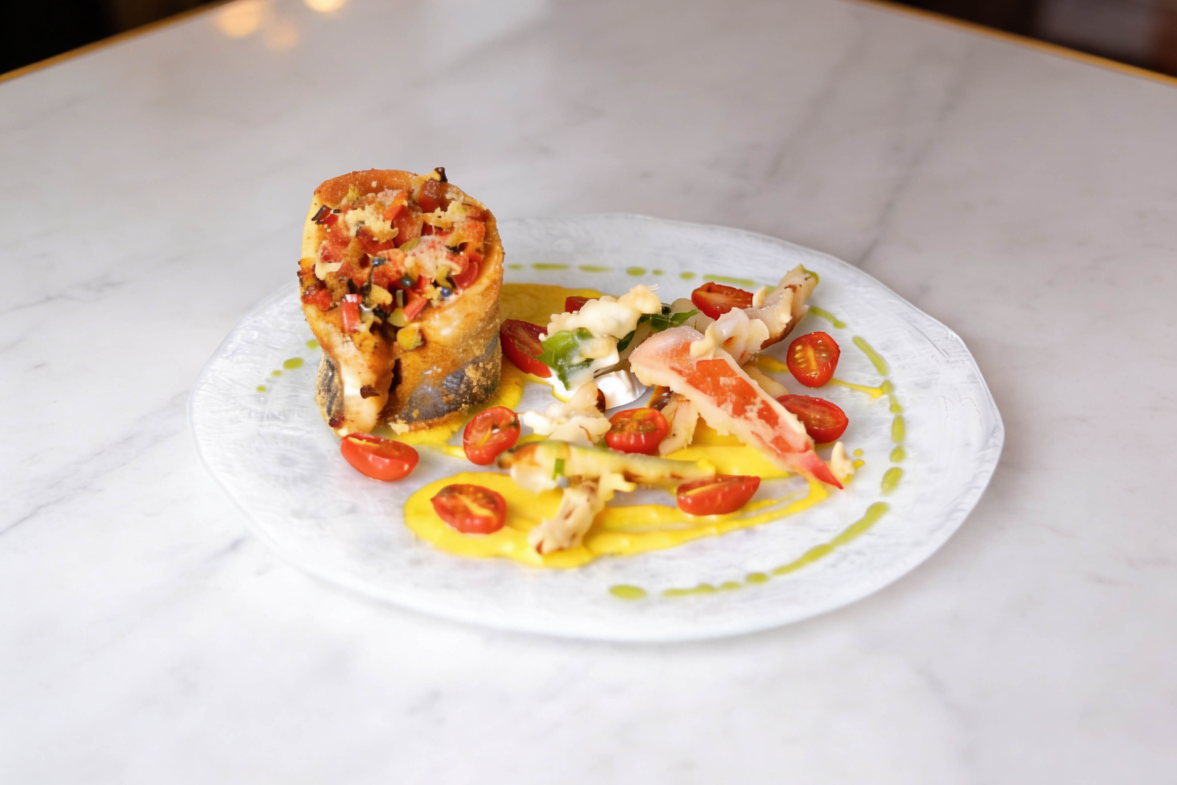 Turbante di spigola ripieno di ratatouille speziata su crema di peperone giallo